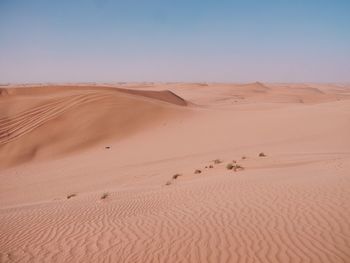 Sand dunes in desert against clear sky