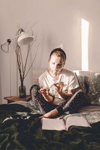 Young woman sitting on sofa at home