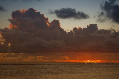 Scenic view of sea against dramatic sky during sunset