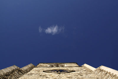 Low angle view of ruined building against blue sky