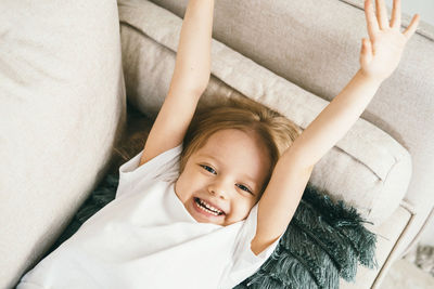 A 4-year-old girl stretches on the couch.