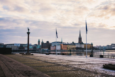 View of buildings in city against cloudy sky