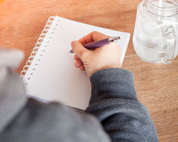 Hand writing with pen in book