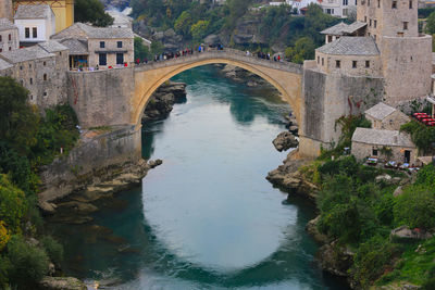 High angle view of arch bridge over river amidst buildings