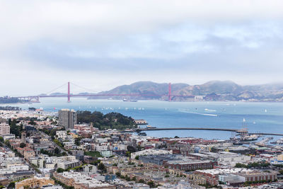 High angle view of city by sea against sky