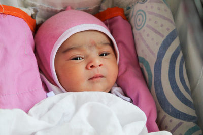 Portrait of cute new born baby girl in pink outfit.. watchful mood