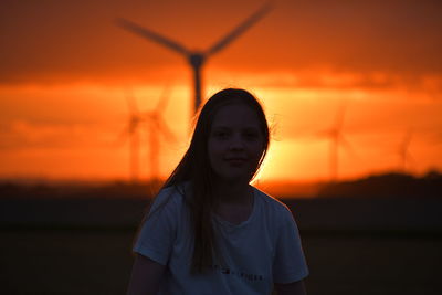 Girl and sunset over the holderness fields at rimswell east yorkshire uk wind turbine in background