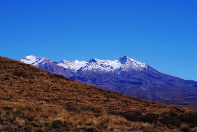 Scenic view of snowcapped mountains against clear blue sky