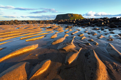 Surface level of rocks on shore against sky
