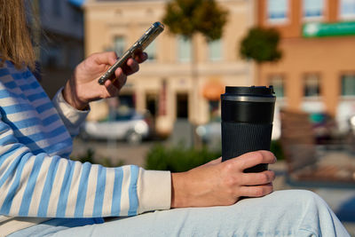 Midsection of woman using mobile phone