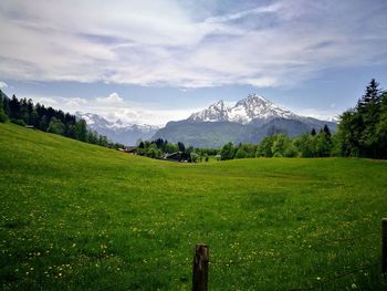 Scenic view of field and mountains against sky