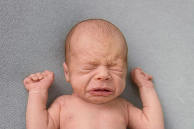 Portrait of crying newborn baby. emotions of discontent. colic.