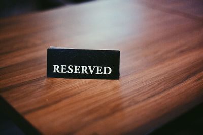 High angle view of reserved sign on wooden table