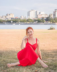 Portrait of young woman sitting on field