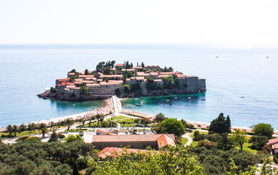 Scenic view of sea and buildings against clear sky