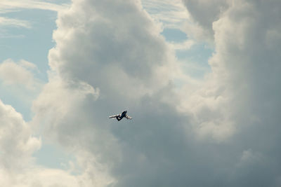 Low angle view of airplane flying against sky