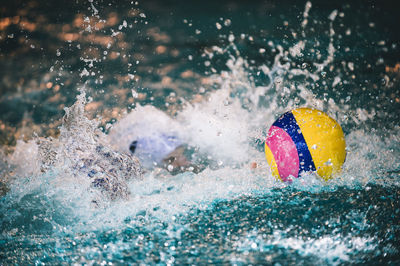 Man splashing water in swimming pool