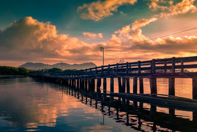 Bridge over river against sky during sunset