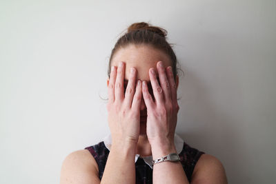 Close-up of young woman covering face with hand