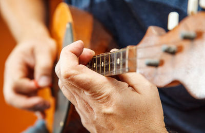 Midsection of man playing string instrument