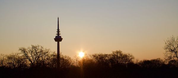 Silhouette of communications tower during sunset