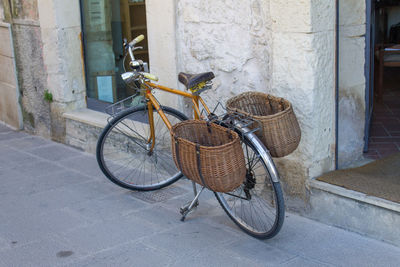 Bicycle in basket on street against building