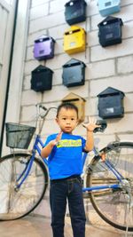 Low angle view of boy with bicycle and mailbox