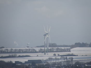 Windmills on field against sky