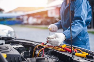 Midsection of man working in car