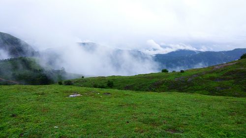 Scenic view of mountains against cloudy sky