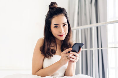 Portrait of young woman using mobile phone