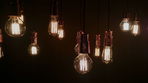 Close-up of illuminated light bulbs hanging on ceiling