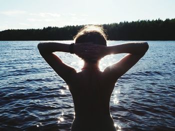 Rear view of woman standing in lake