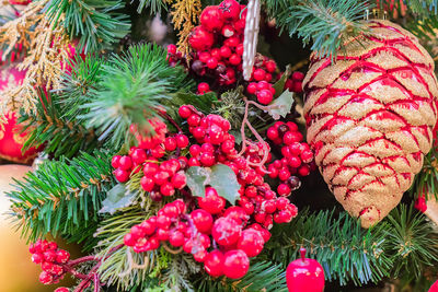 Christmas and new year holidays background. christmas tree decorated red frosted berries and cones.