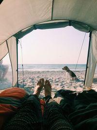 Low section of man relaxing on beach