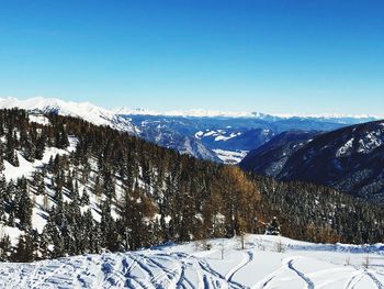 Scenic view of snow covered mountains against clear sky