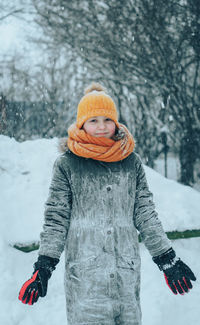 Portrait of girl standing on snow covered land
