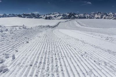Tire tracks on snow covered landscape