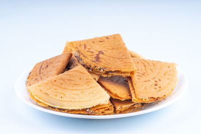 Close-up of bread in plate against white background