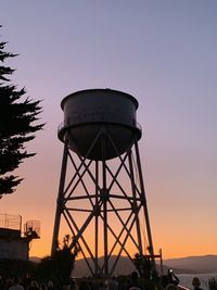 Low angle view of water tower against sky during sunset