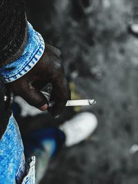 Midsection of man holding cigarette