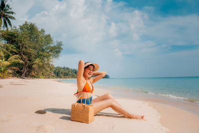 Woman on beach by sea against sky