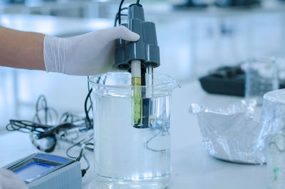 Cropped hand of scientist examining chemical in laboratory