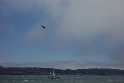 Airplane flying over sea against sky