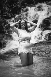 Portrait of a smiling young woman standing in water