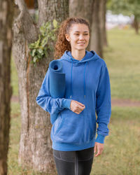 Portrait of young woman standing in forest