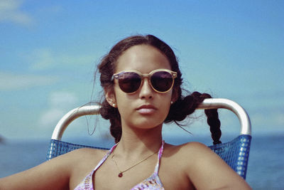 Portrait of girl wearing sunglasses against blue sky
