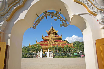 Temple by building against sky