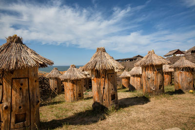 Panoramic view of bee hives on field against sky