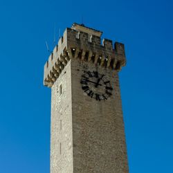 Low angle view clock tower against clear blue sky